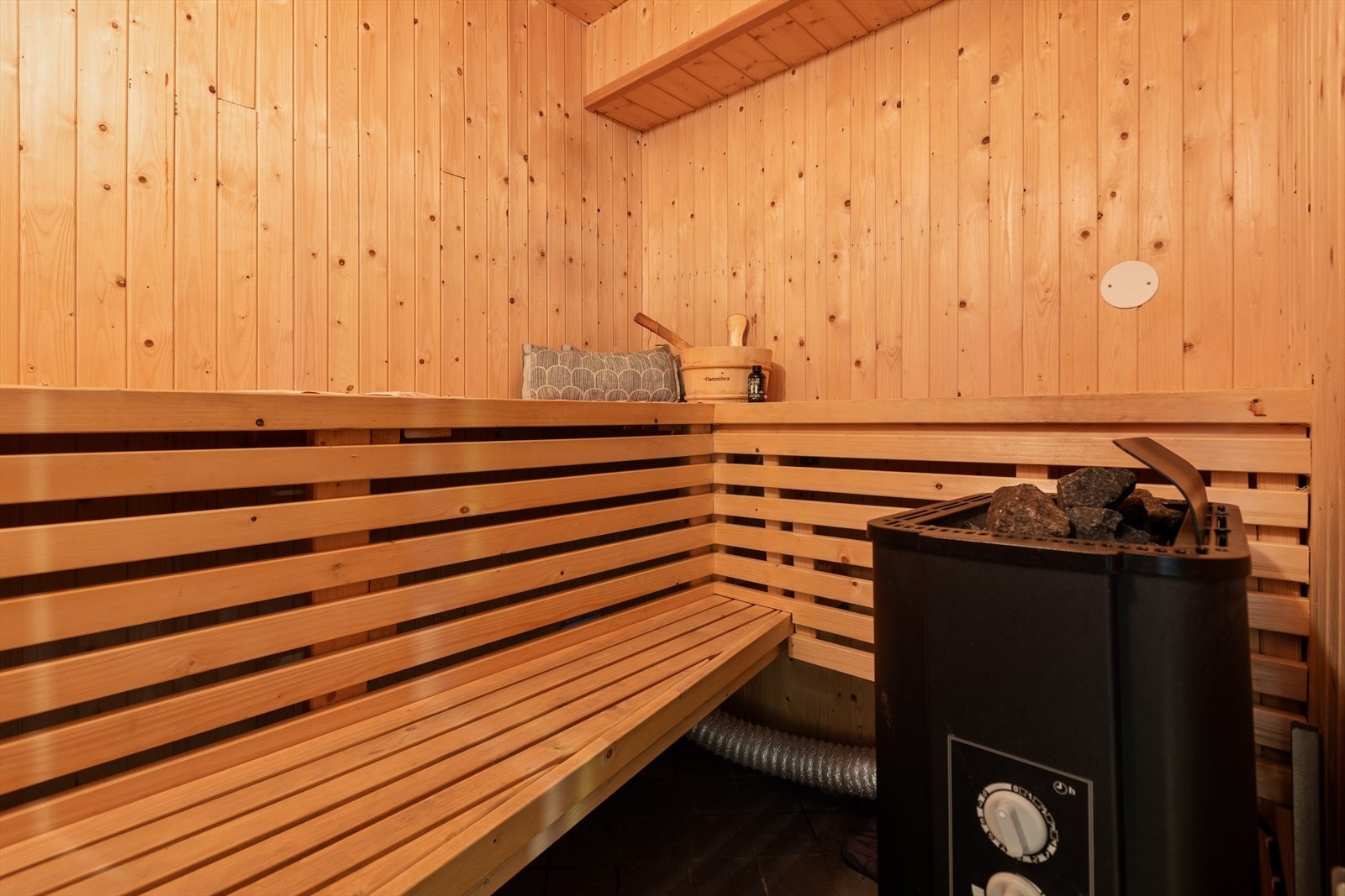 Fra badet er det direkte adgang til badstuen, som er innredet med trebenker og badstueovn. Galleribilde