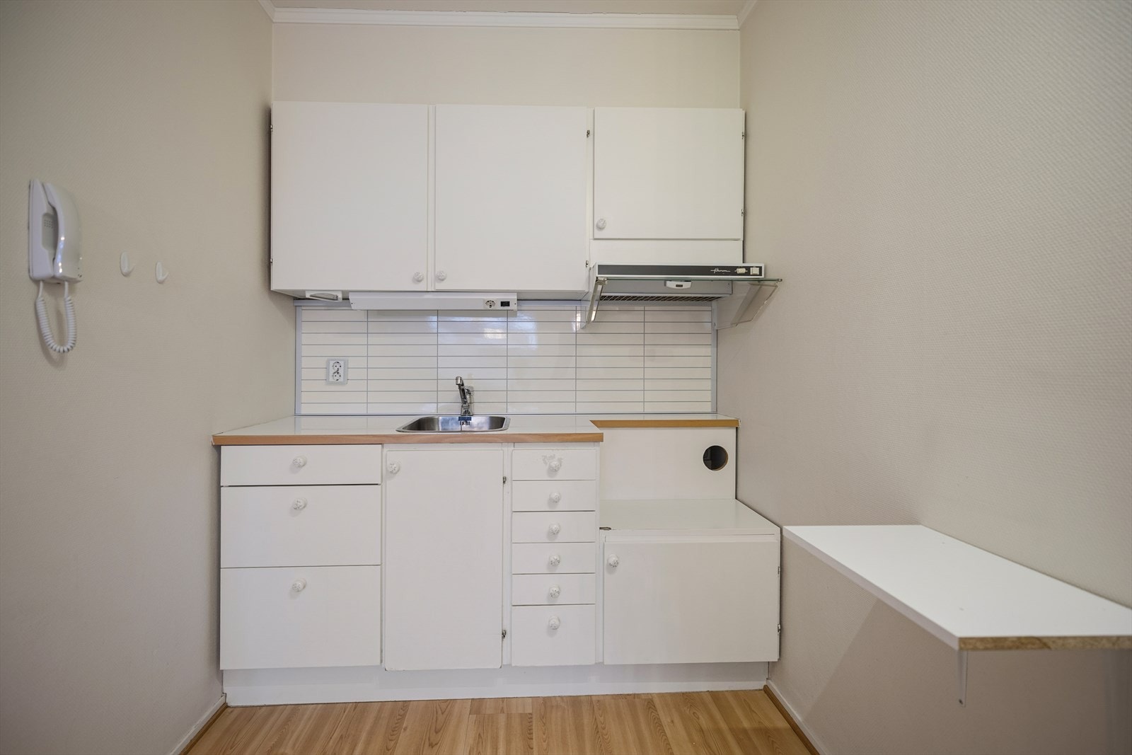 Kjøkkenet har innredning med glatte fronter. Benkeplaten er av laminat med oppvaskkum i rustfritt stål. Galleribilde