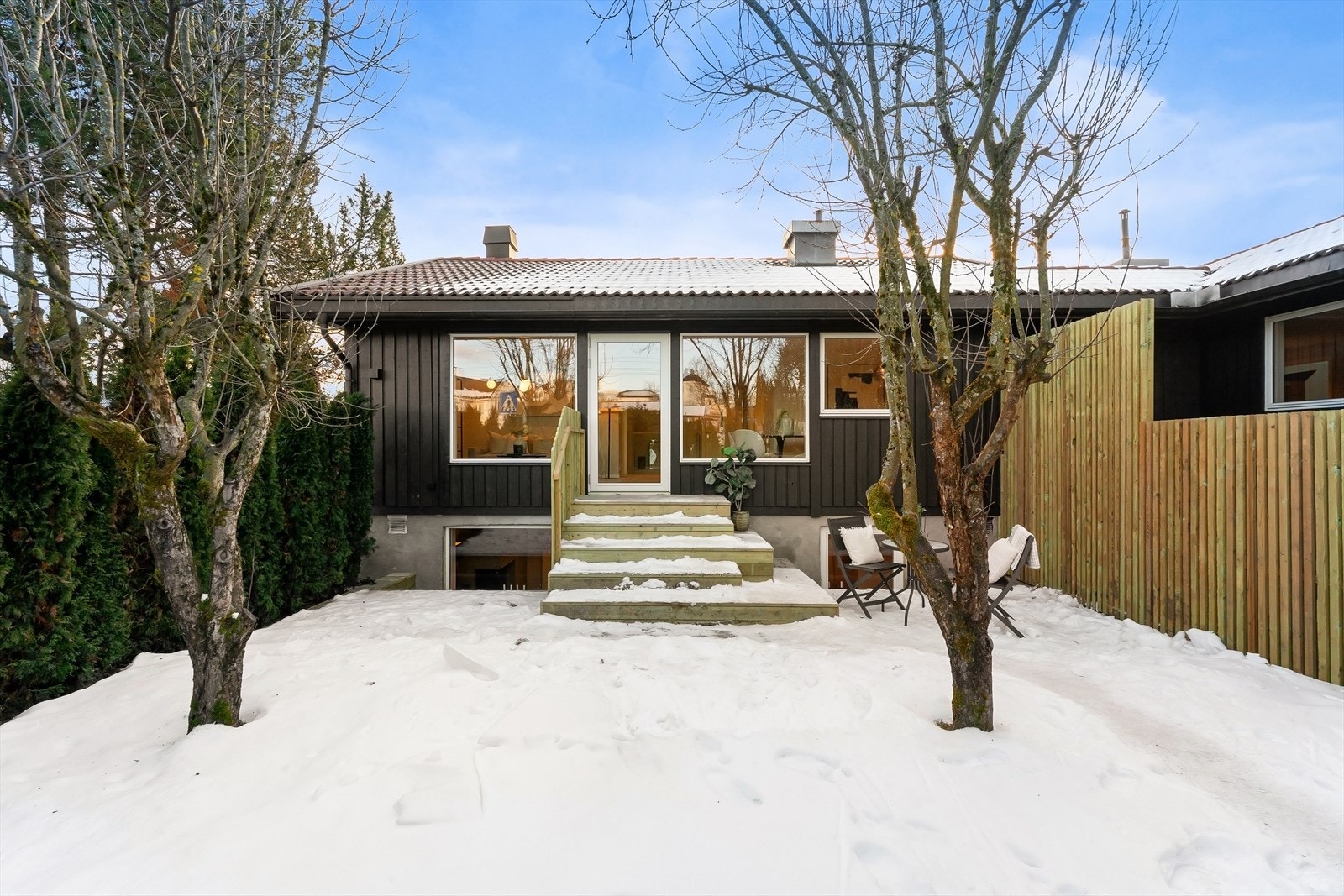 Terrassen omkranses av spilevegger og trær som gir følelse av privatliv. Galleribilde