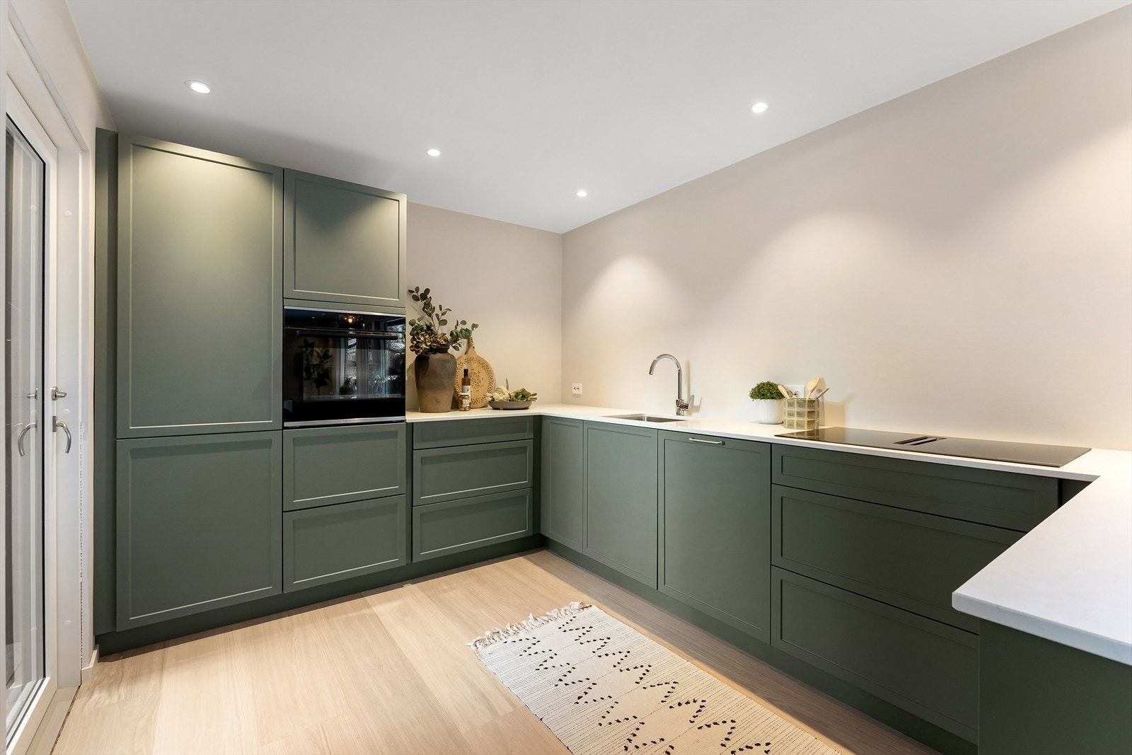 Velutstyrt Kvik kjøkken fra 2025 med matte profilerte fronter. Kompositt benkeplate med underlimt vaskekum og nedfelt induksjon platetopp. Galleribilde