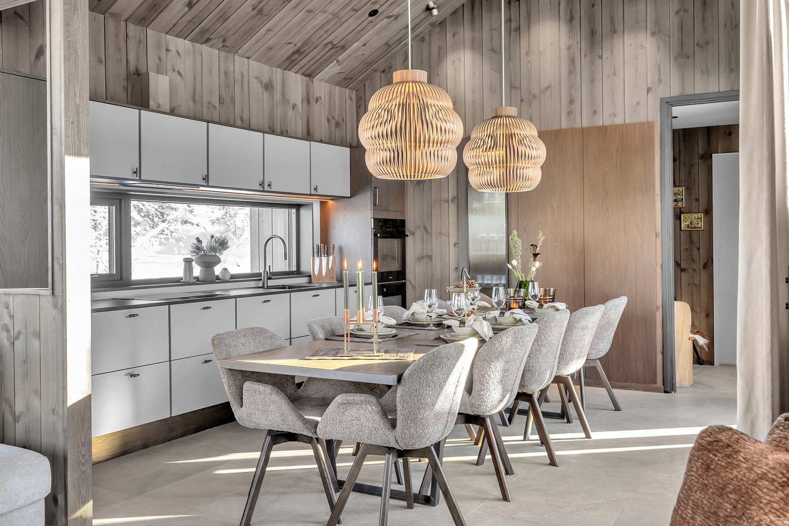 Åpen kjøkkenløsning med lyse skap, integrerte hvitevarer og utgang tomten Galleribilde