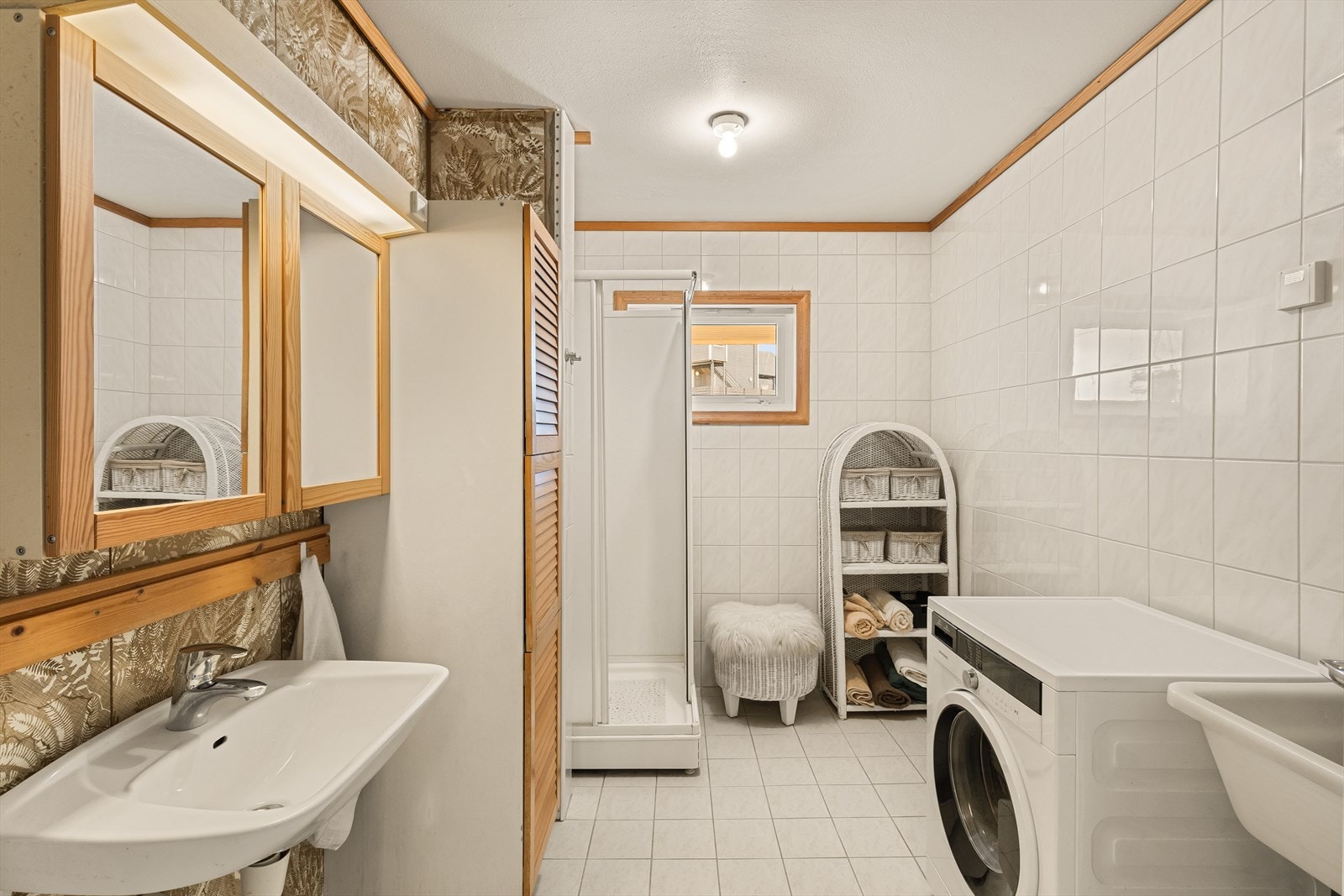 Badet er innredet med servant, overskap, speil, toalett og dusjkabinett. Varmekabler i gulvet. Galleribilde