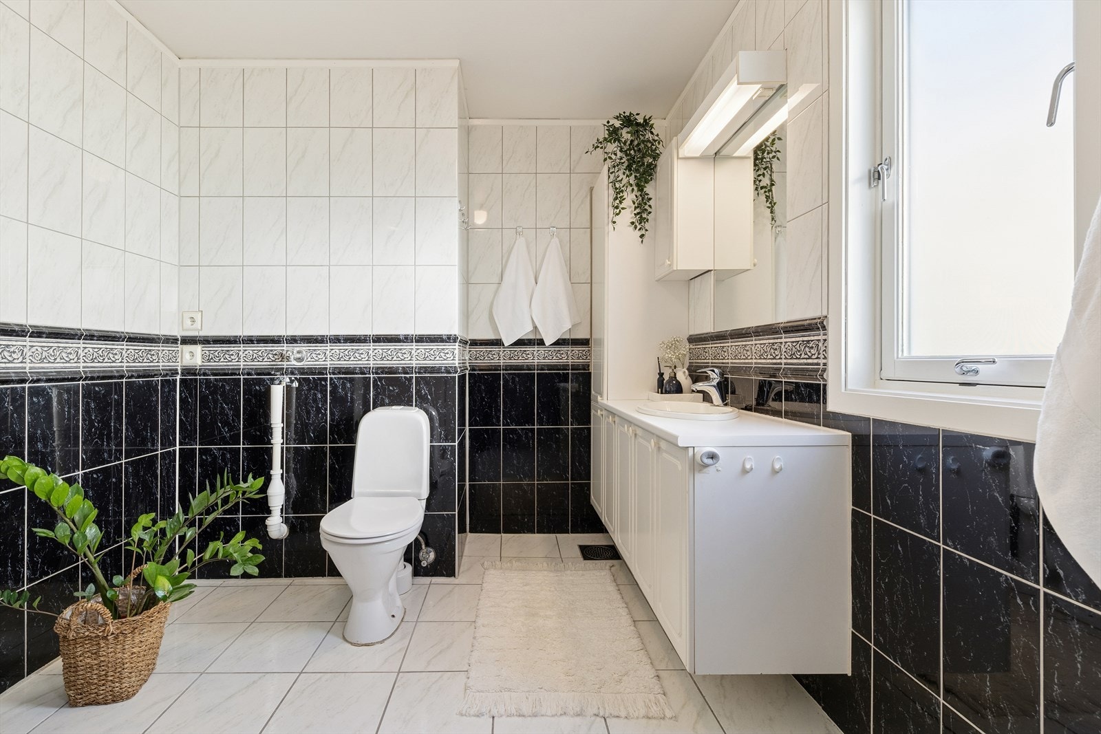 Helfliset bad/vaskerom fra byggeår. Varme i gulv. Rommet har innredning med nedfelt servant, toalett, opplegg til vaskemaskin og dusjhjørne. Mekanisk avtrekk via ventil i vegg styrt av kjøkkenveiltator og luftespalte i dør. Galleribilde