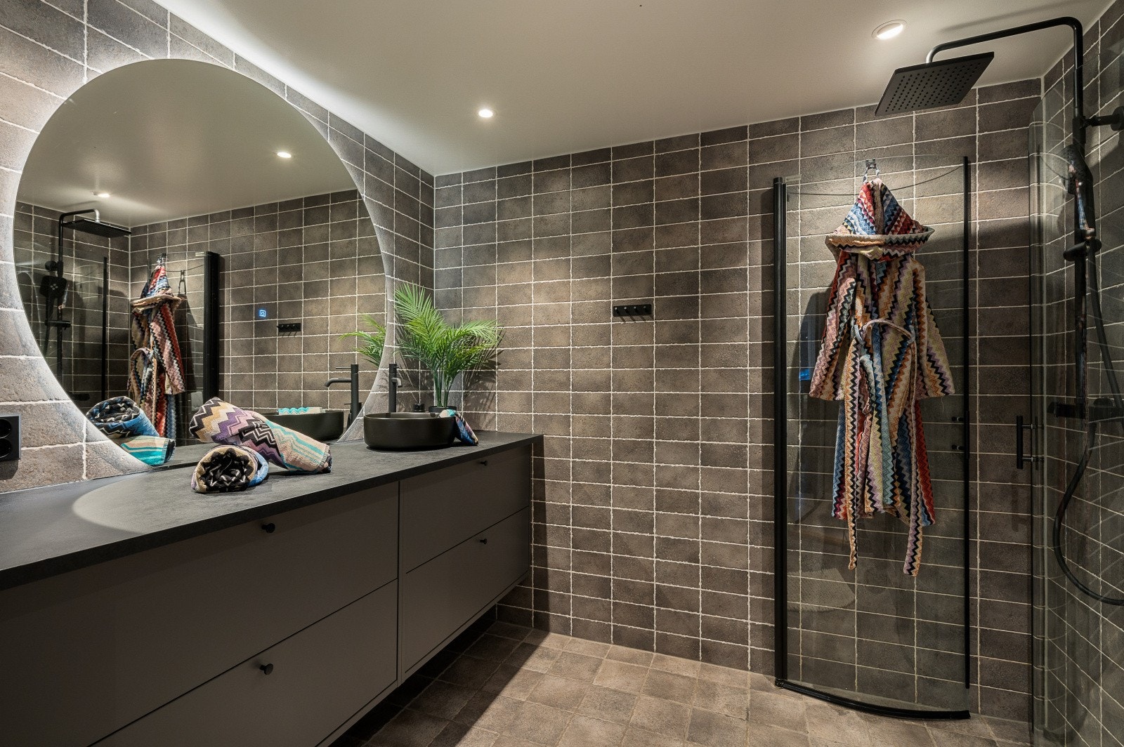 Romslig og delikat baderom med servantinnredning, godt speillys og dusj med glassdører. Galleribilde