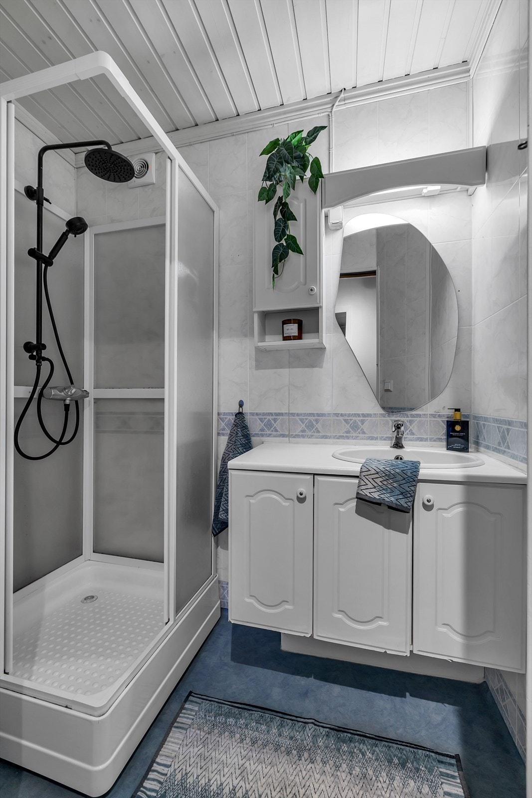 Bad med dusjkabinett med avrenning rett i sluk. Innredning med god oppbevaringsplass. Galleribilde