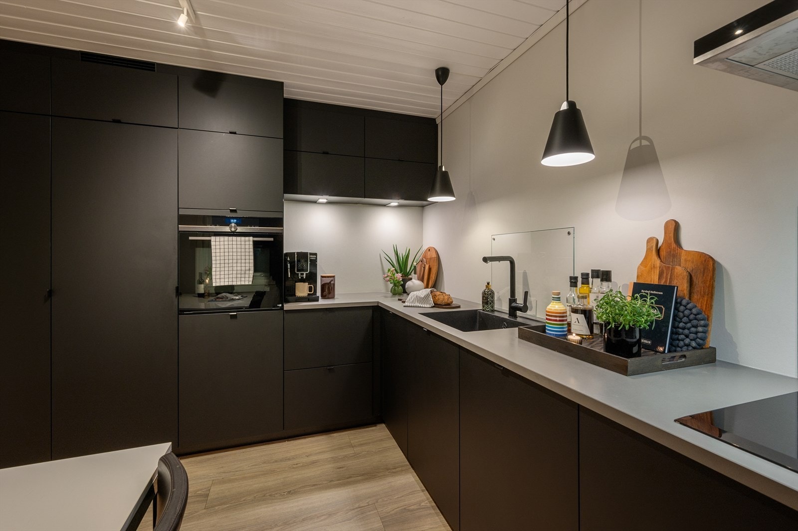 Stilrent kjøkken med matte svarte fronter og integrerte hvitevarer fra Siemens Galleribilde