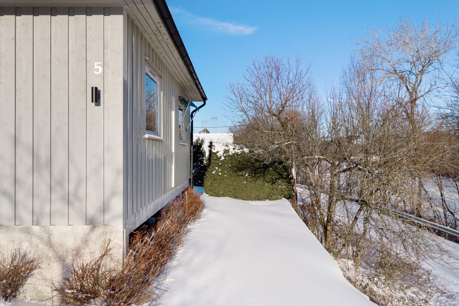 Hage i forkant av boligen beplantet med plen, hekk og beplantning Galleribilde