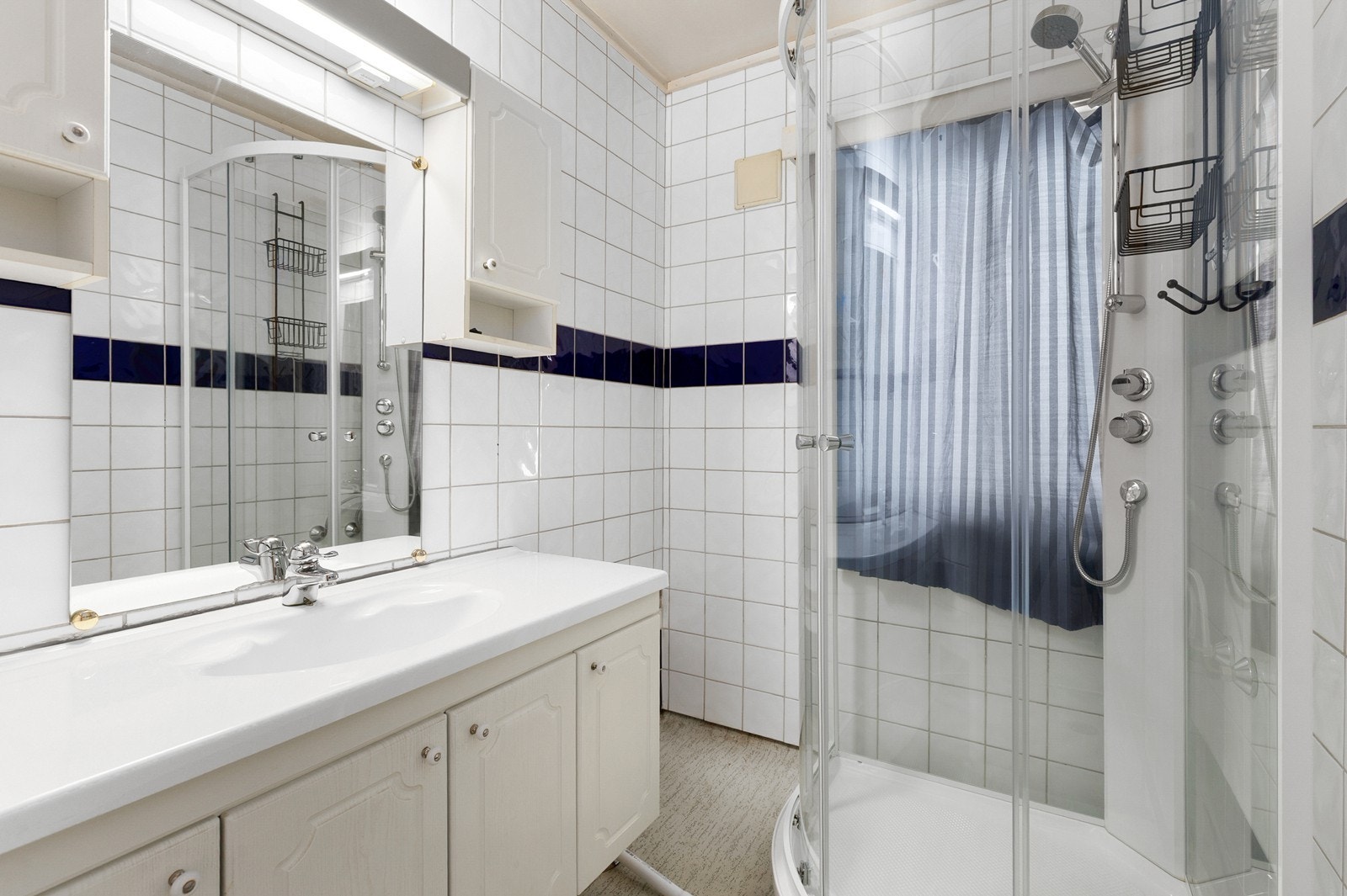 Bad med flislagte vegger og våtromsbelegg på gulv. Godt med skapplass, samt nytt dusjkabinett Galleribilde