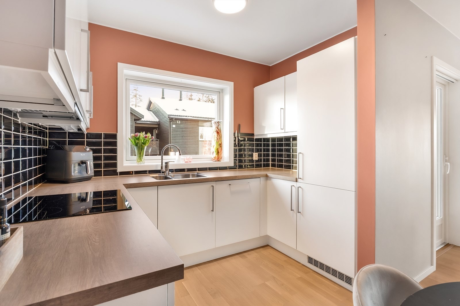 Det er montert fliser på veggen mellom benkeplaten og overskapene. Galleribilde