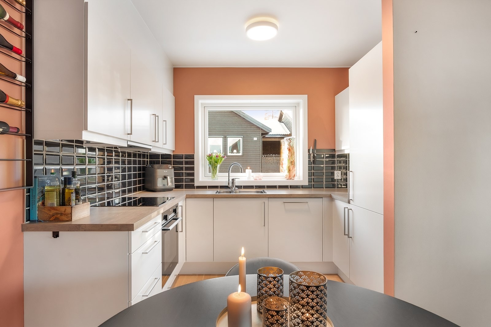 Kjøkkeninnredningen er vinkelformet og har stilrene hvite, glatte fronter og laminert benkeplate. Galleribilde