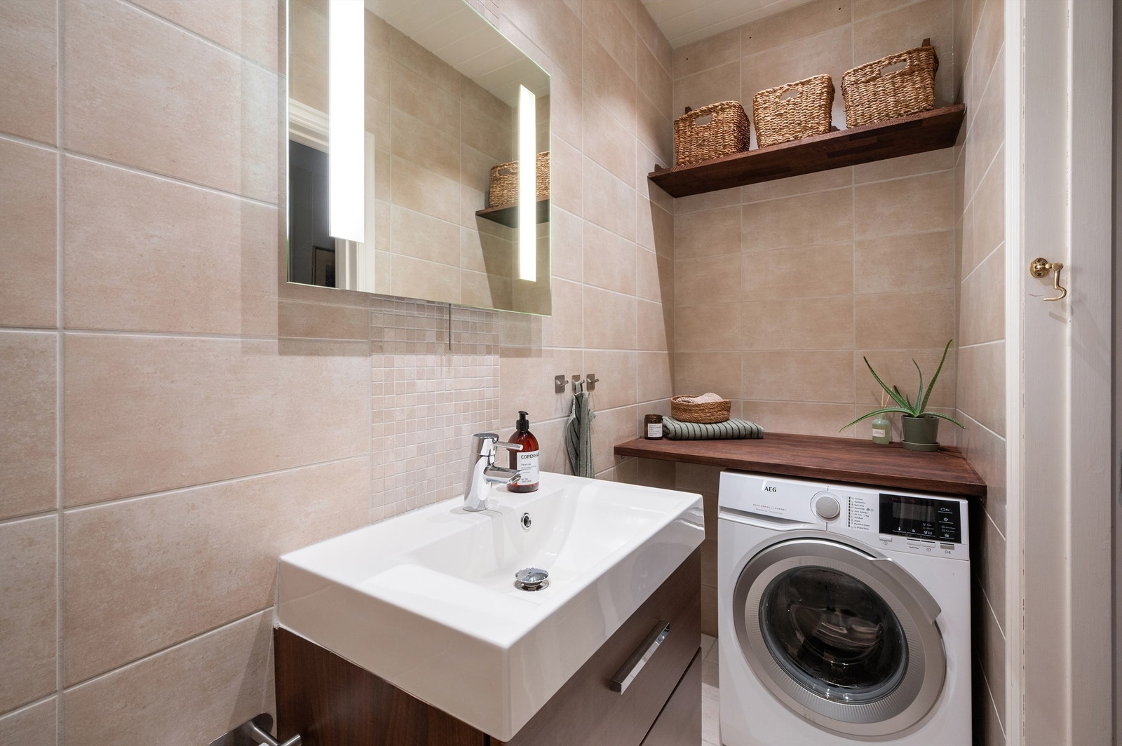 Badet har en praktisk løsning med opplegg for vaskemaskin under benkeplaten. Galleribilde