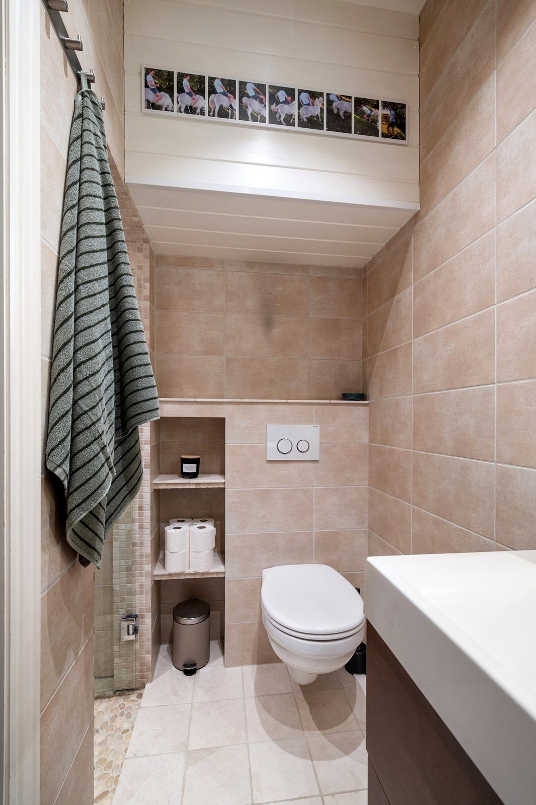 Vegghengt toalett og smarte oppbevaringsnisjer gir et ryddig og arealeffektivt baderom. Galleribilde