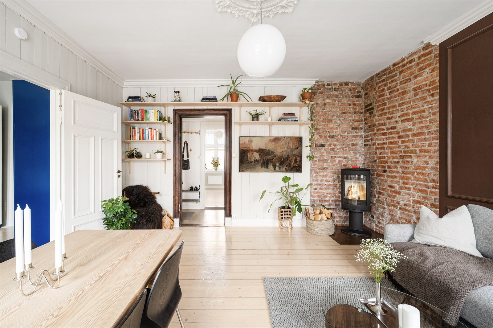 Den stemningsfulle vedovnen, satt mot en eksponert teglsteinsvegg, gir både varme og karakter. Galleribilde