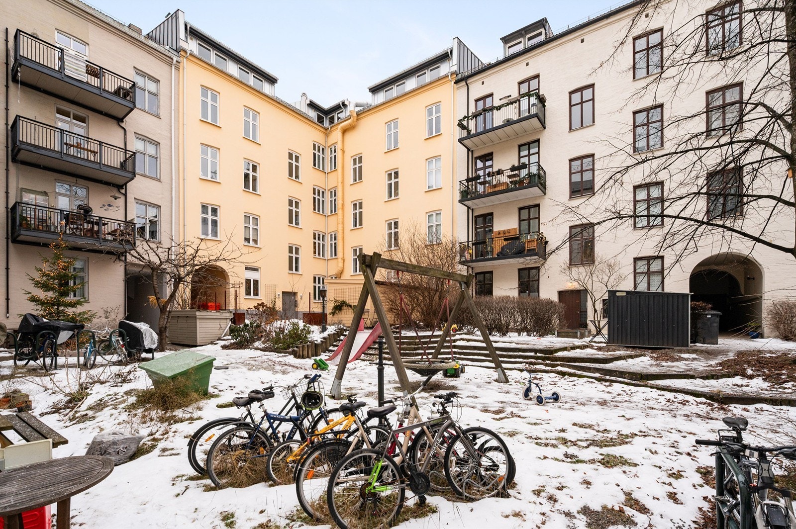 Den felles bakgården er en skjermet oase med sitteplasser og lekeapperater. Galleribilde