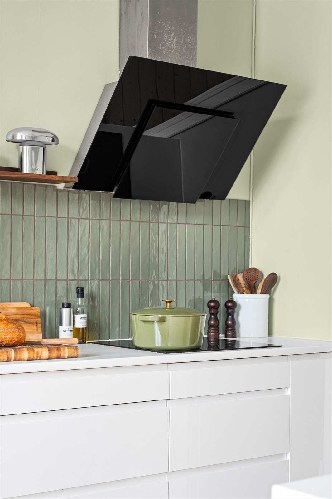 Moderne induksjonstopp og en stilren, skråstilt ventilator over kokesonen. Galleribilde