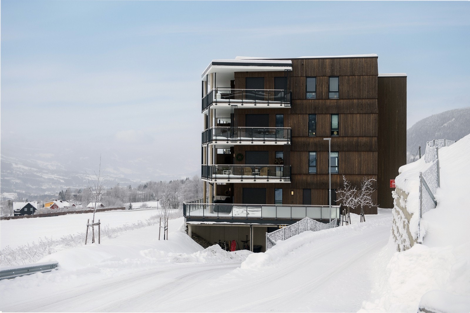 Bygget har en stilren arkitektur med trepanel og store glassflater. Galleribilde