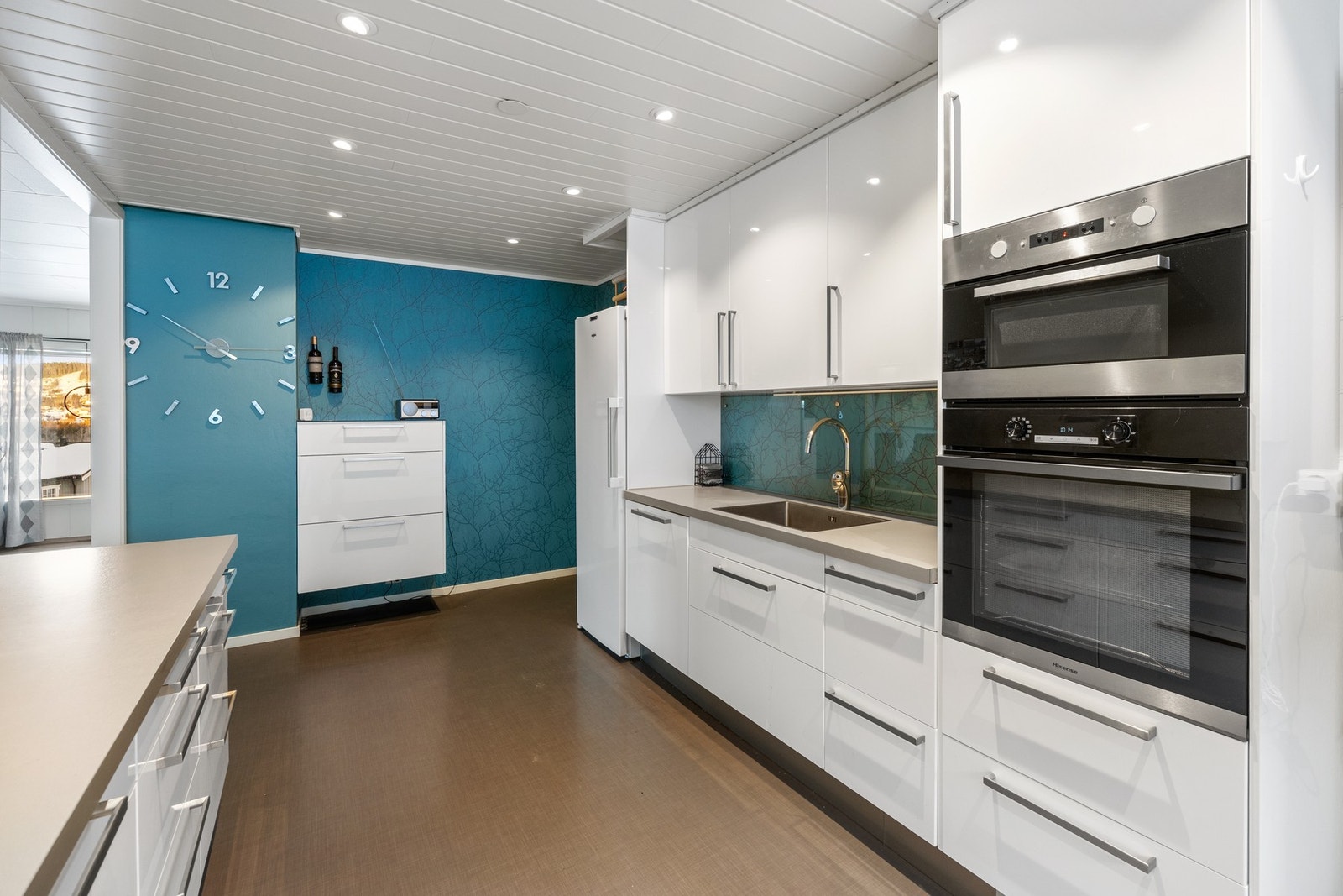 Pen og praktisk kjøkkeninnredning med integrert oppvaskmaskin, platetopp, mikroovn og stekeovn. Galleribilde