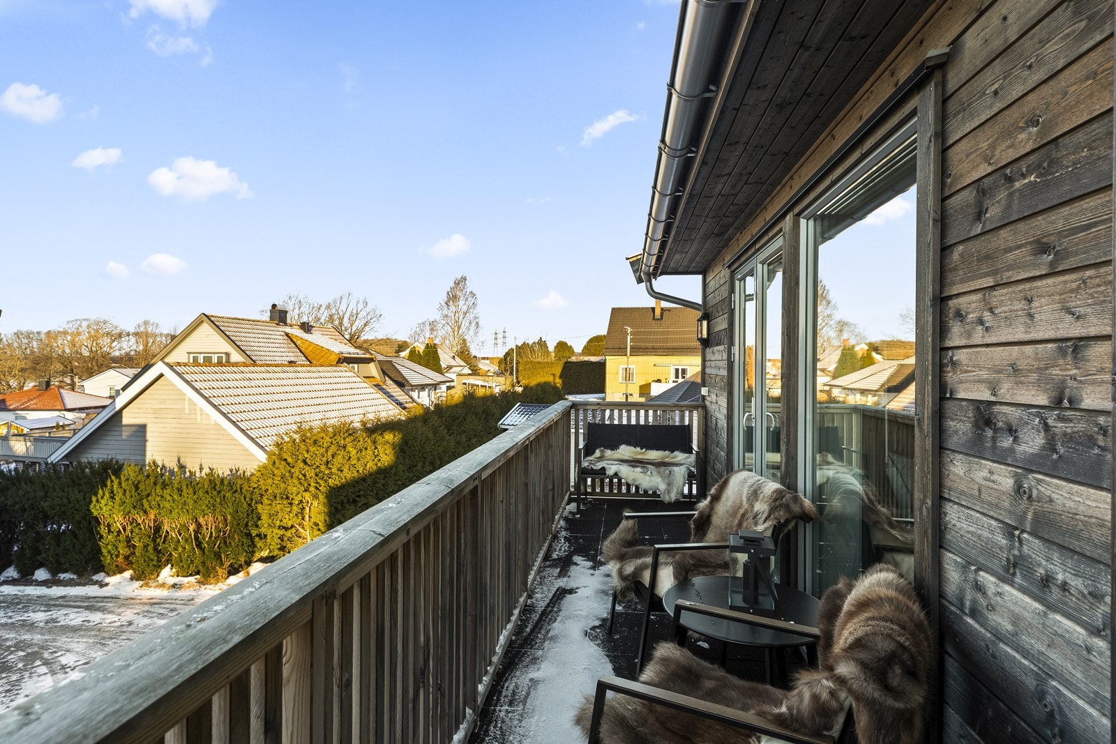 Balkongen har liggende bordkledning og gir utsyn over nabolaget. Galleribilde