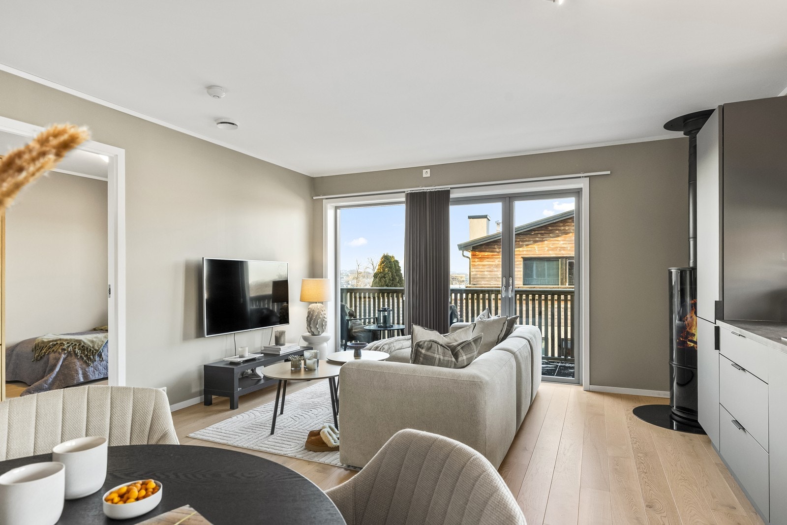 Store vindusflater gir utsyn mot uteområdet fra stuen. Galleribilde