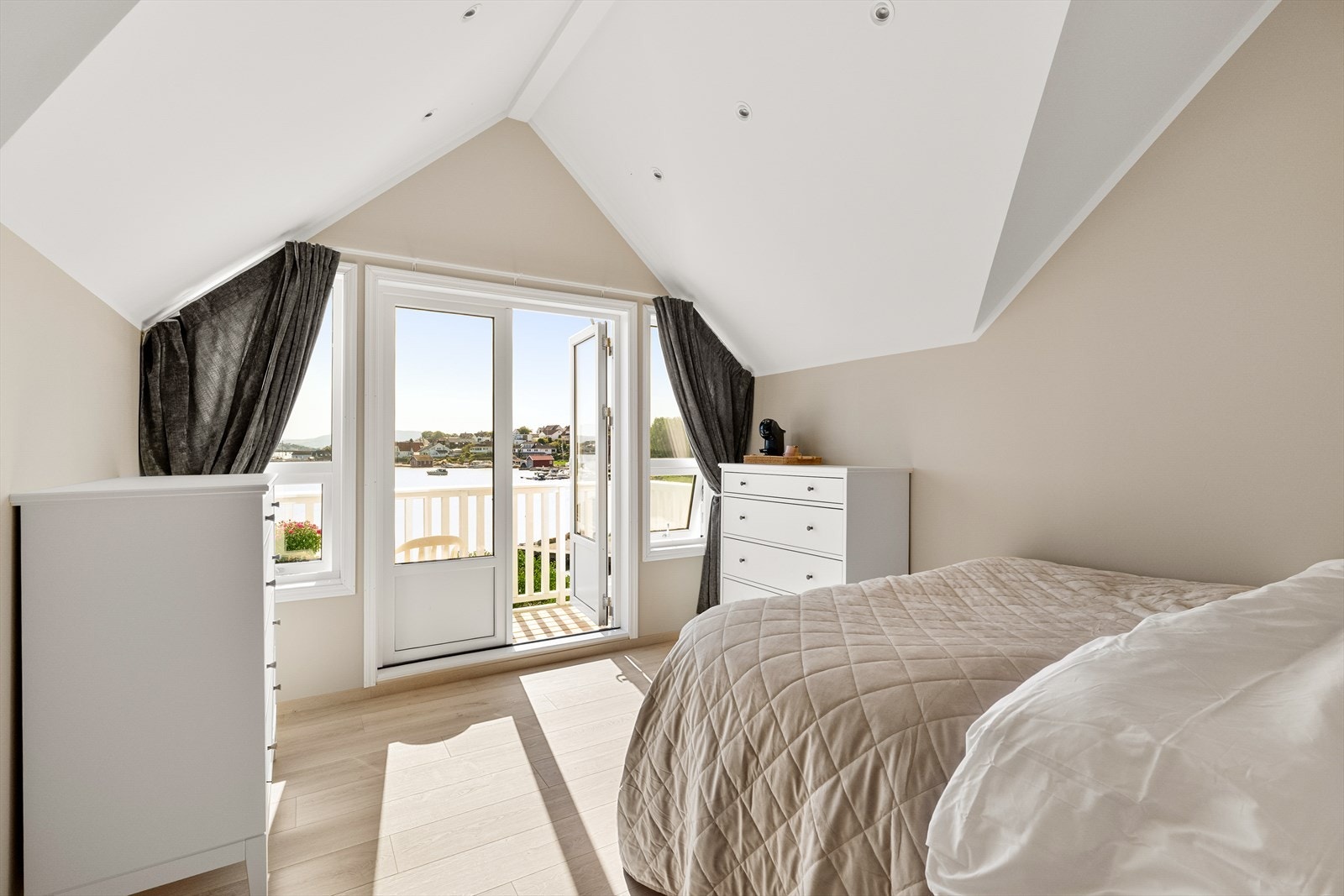 Lyst og innbydende soverom med store vinduer, som gir flott utsikt mot sjøen og mye naturlig lys. Galleribilde