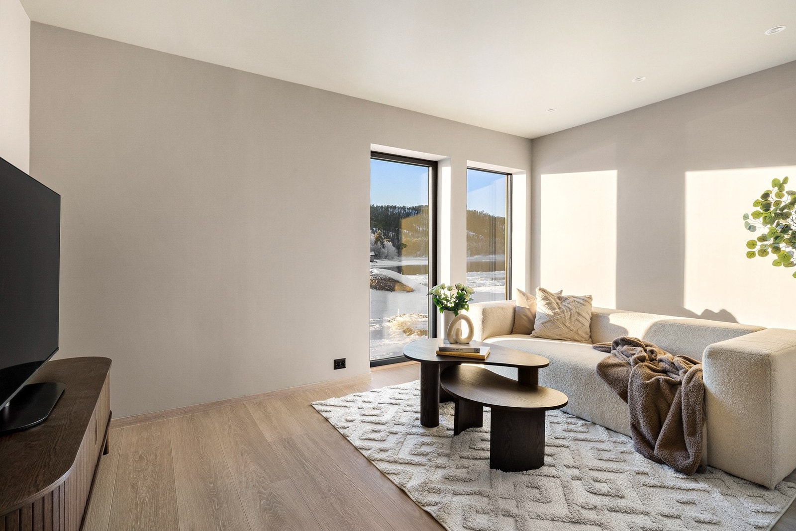 Lys og romslig TV-stue med fleksible løsninger for hele familien Galleribilde