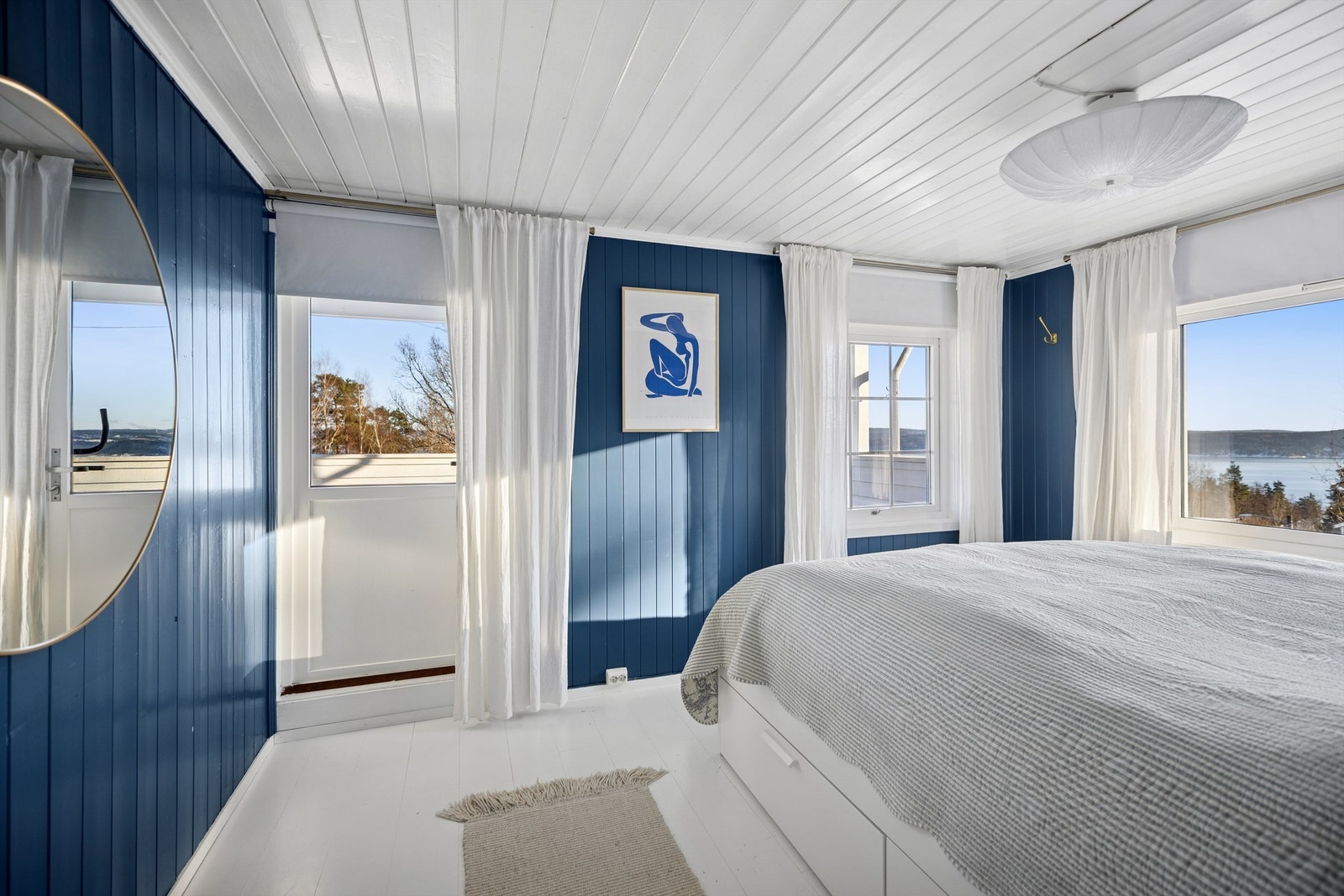 Hovedsoverommet fremstår som lyst og innbydende, med nydelig fjordutsikt og direkte utgang til en solrik takterrasse. Galleribilde