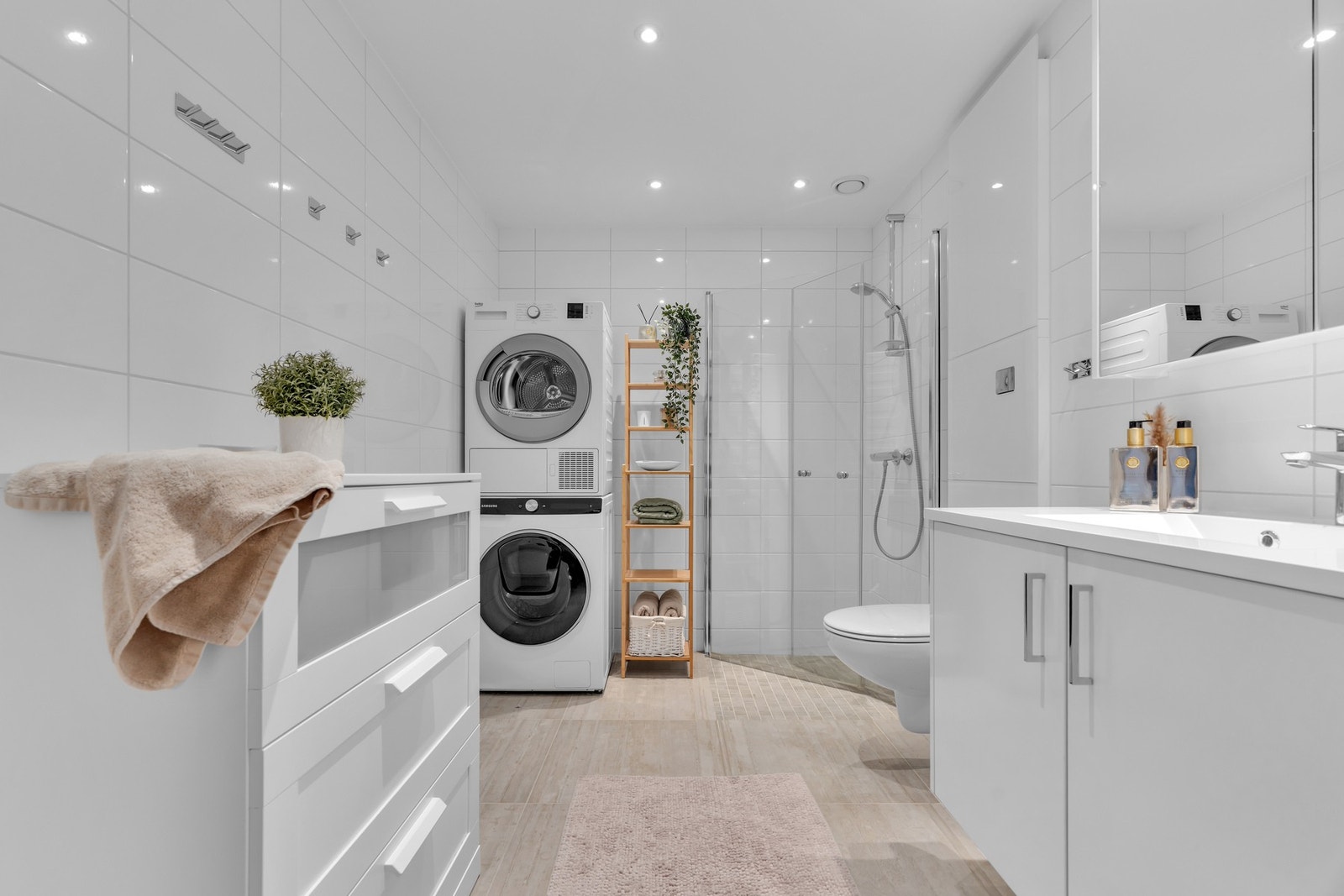 Badet er fliselagt og innredet med dusjnisje, vegghengt toalett og opplegg for vaskemaskin og tørketrommel. Galleribilde