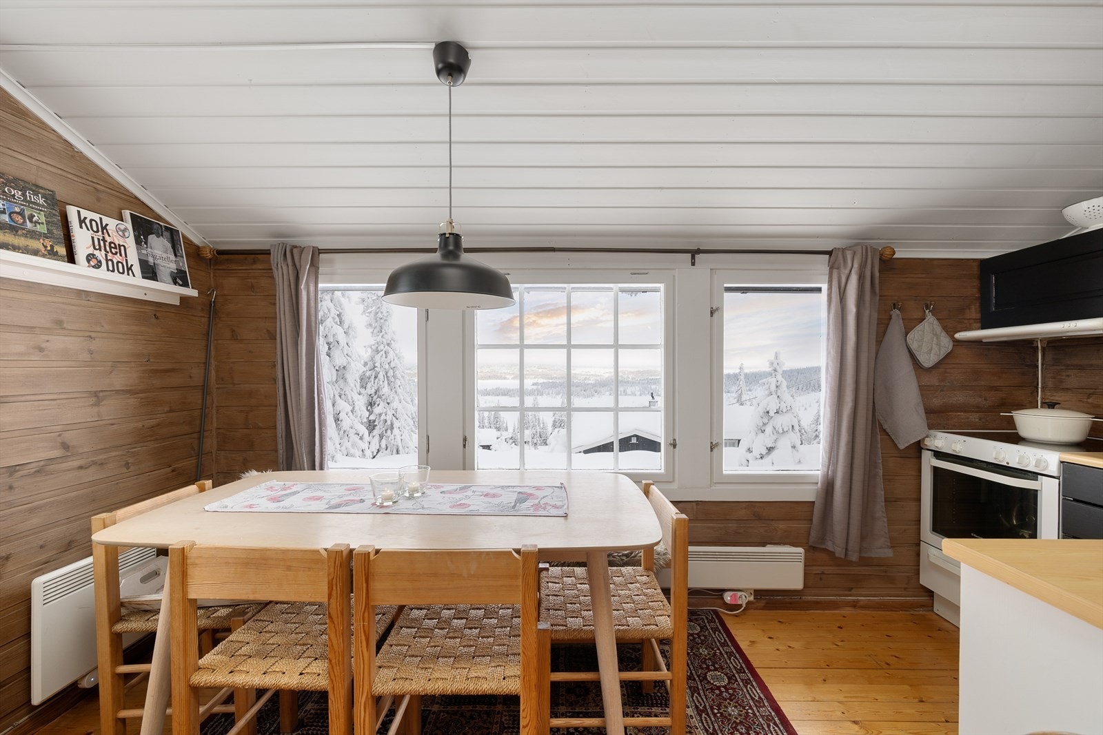 Kjøkkenet har plass til spisebord. Et hyggelig og naturlig samlingssted i hytta. Galleribilde