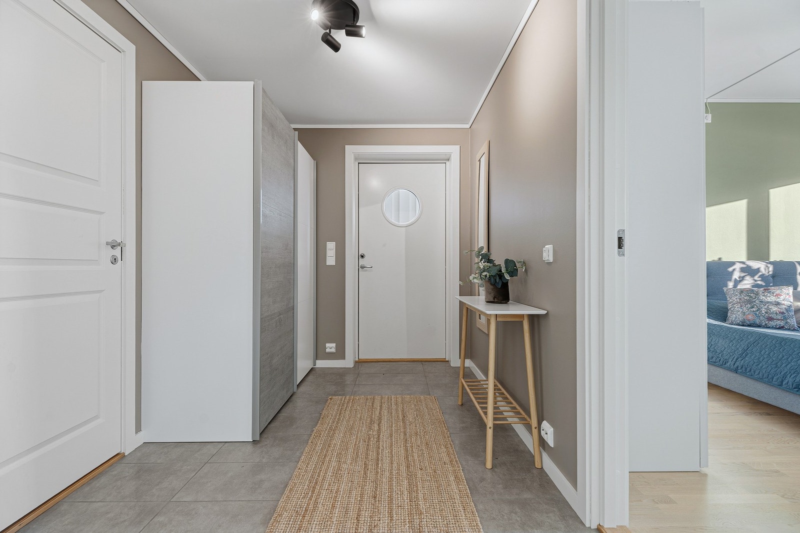 Entreen er innbydende med fliser på gulvet med varmekabler, lysmalte overflater og har skyvedørsgarderobe. Galleribilde