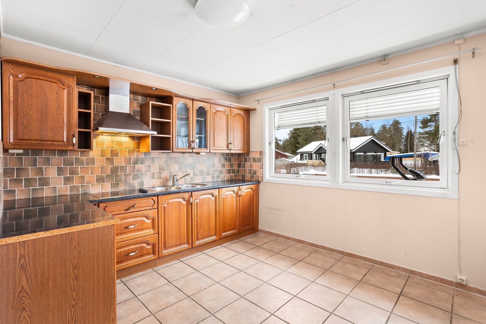 Kjøkkeninnredning i tre med god skap- og benkeplass. Galleribilde