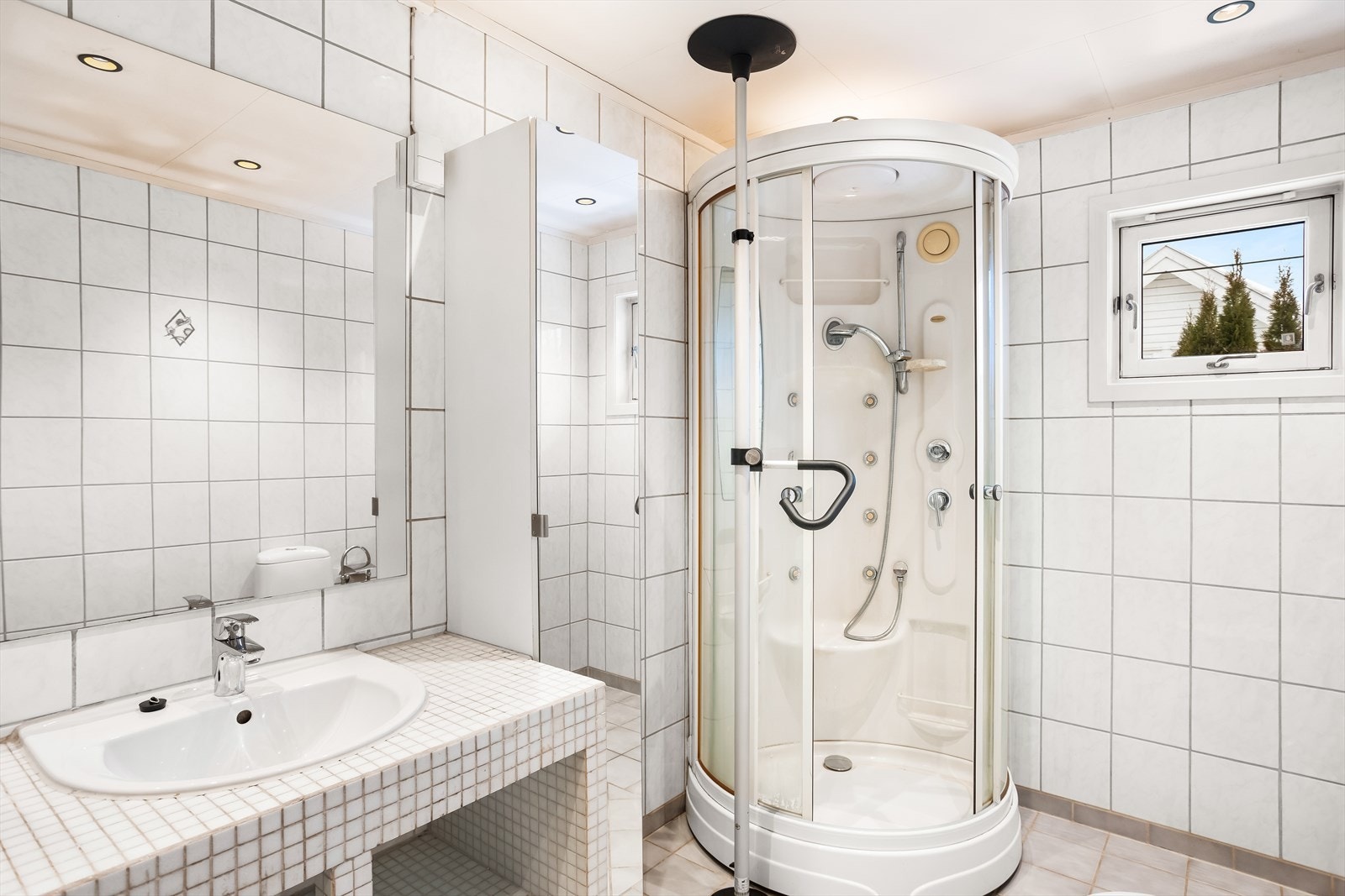 Badet er helfliset og utstyrt med dusjkabinett og servant med oppbevaring. Galleribilde