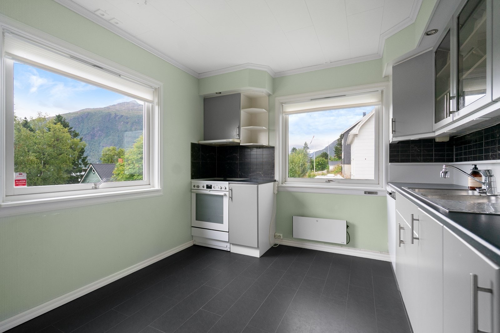 Kjøkkenet har store vindusflater som gir rikelig med arbeidslys og utsikt mot naturen rundt Galleribilde