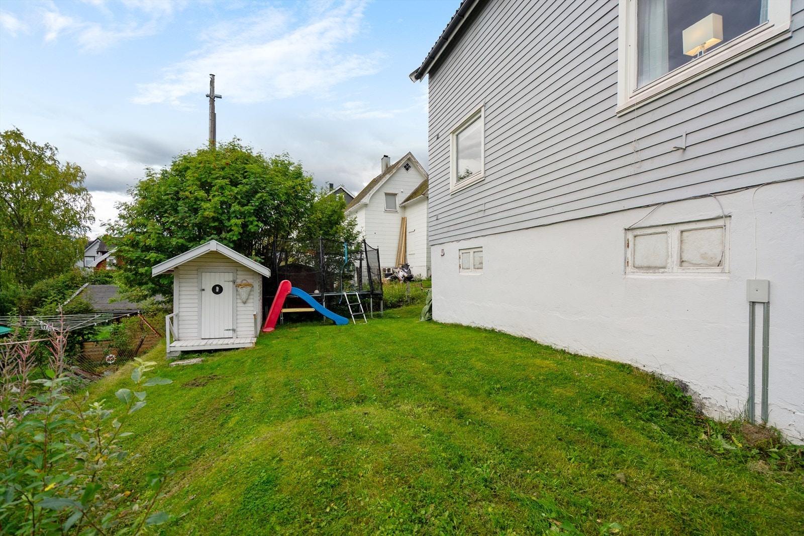 Barnevennlig hage med god boltreplass, trampoline og en sjarmerende lekestue som gir glede for familiens minste Galleribilde