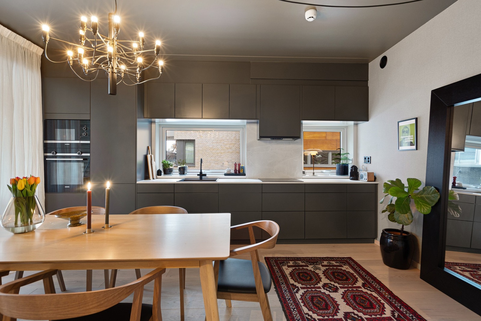 Kjøkkenet er moderne, stilrent og svært funksjonelt, med glatte, mørke fronter som gir et eksklusivt og rolig uttrykk. Det er god skap- og benkeplass, med laminert benkeplate og nedfelt oppvaskkum som gir en praktisk og ryddig arbeidsflate. Galleribilde