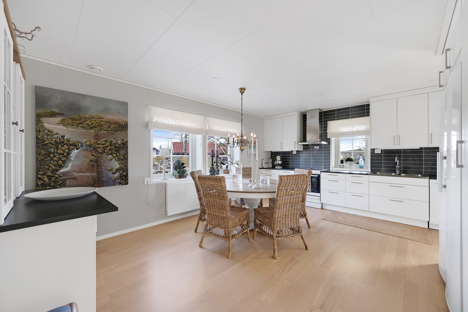 Kjøkkenet er delikat og innbydende med rikelig skap og benkeplass. Innredningen har hvite, profilerte fronter med belysning, 2 kummer og laminert benkeplate. Galleribilde