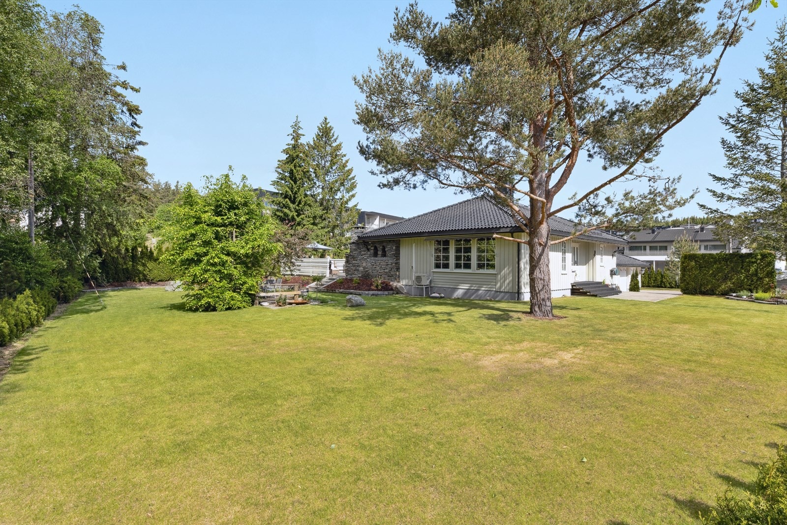 En hage å nyte - flat, romslig og frodig med flere lune uteplasser og plass til både lek og avslapning. Galleribilde