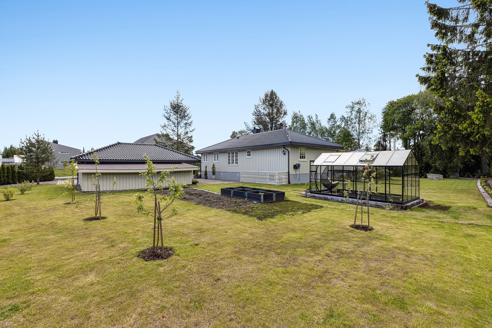 Velstelte uteområder og et sjarmerende drivhus - dette er en hage som skaper ro og glede. Galleribilde