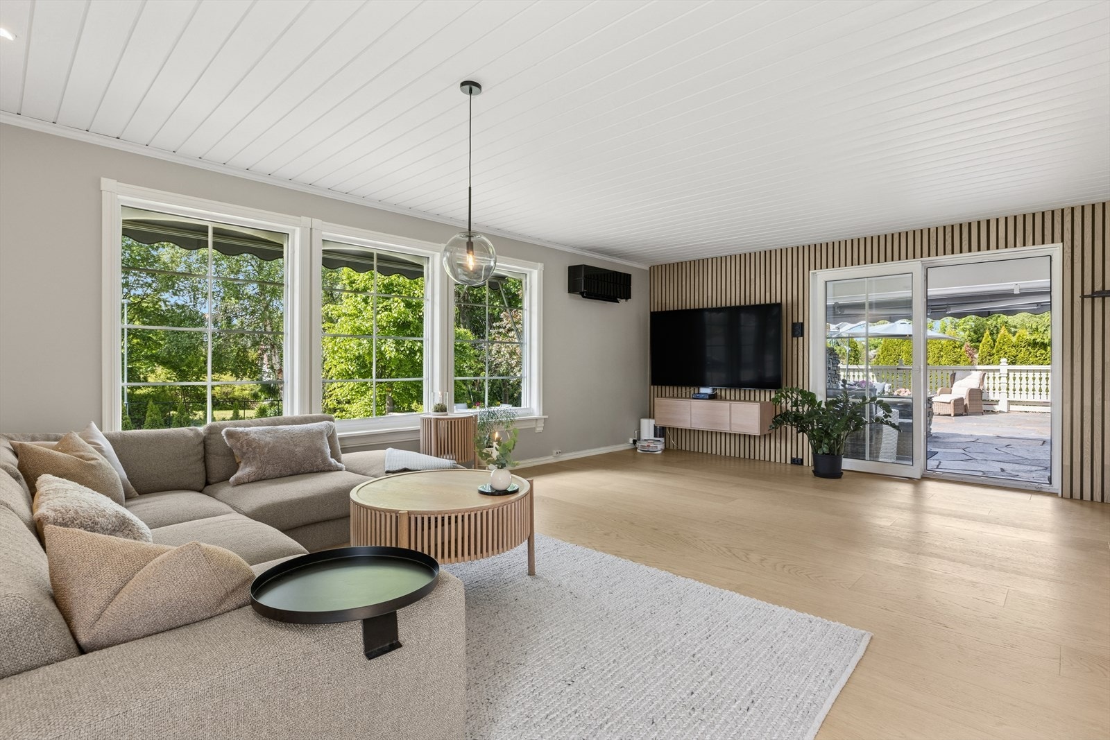 Elegant og åpen stue med smakfulle materialvalg og direkte utgang til terrasse og hage. Galleribilde