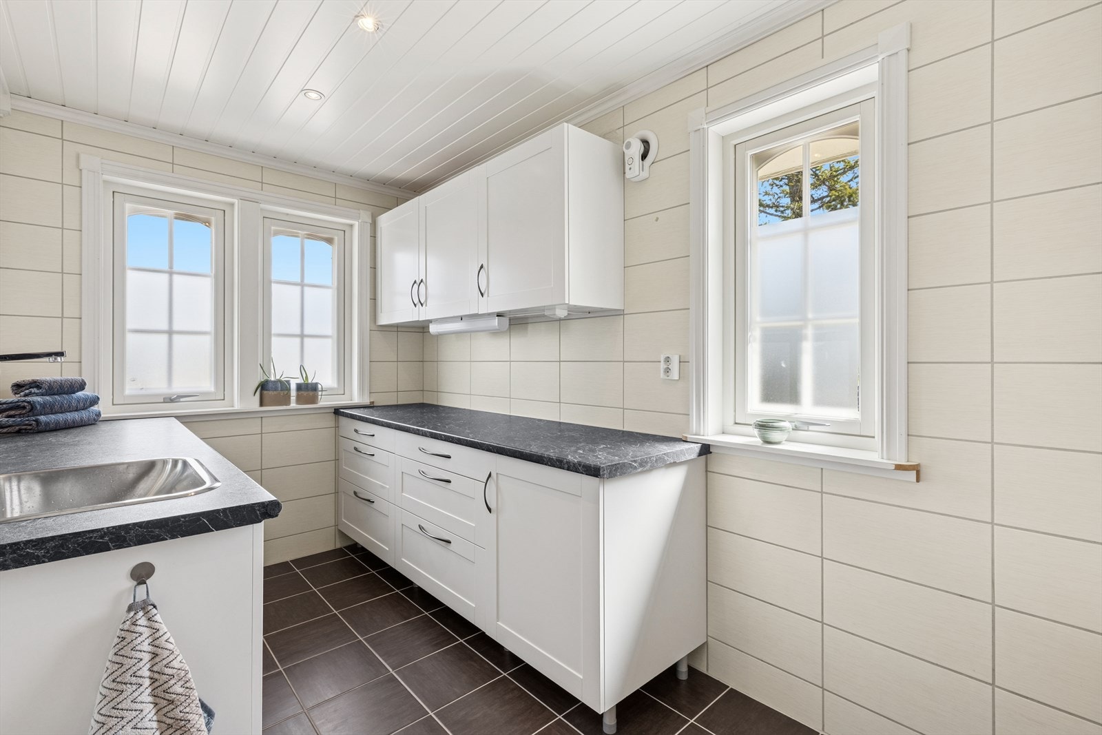 Romslig vaskerom med masse ekstra skapplass. Det er dør fra kjøkkenet og entrèn inn til vaskerommet. Galleribilde