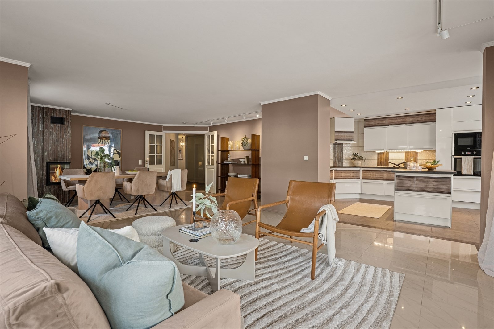 Stuen er delvis åpent mot stort kjøkken med spiseplass Galleribilde