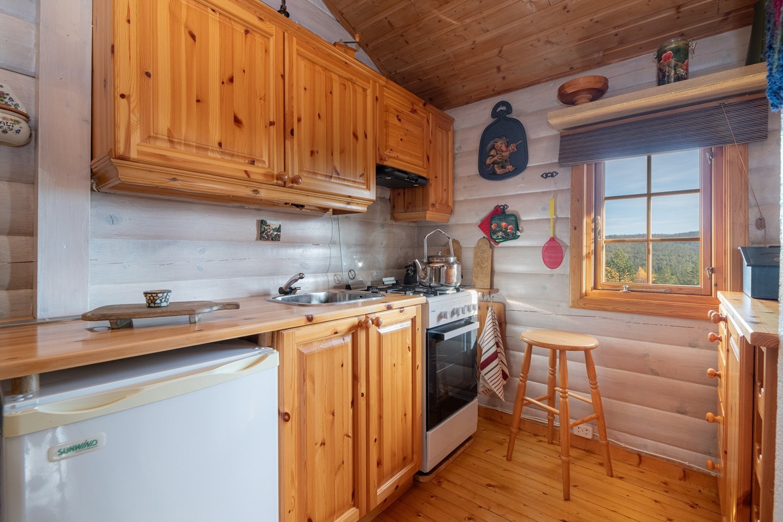 Kjøkkenet har innredning fra 2000 med profilerte fronter og heltre benkeplate.
Her er det kullfilterventilator og opplegg for gasskomfyr og kjøleskap. Hvitevarer medfølger.
Det er vask med vann fra tank med pumpe styrt fra kran. Utslipp av gråvann. Galleribilde