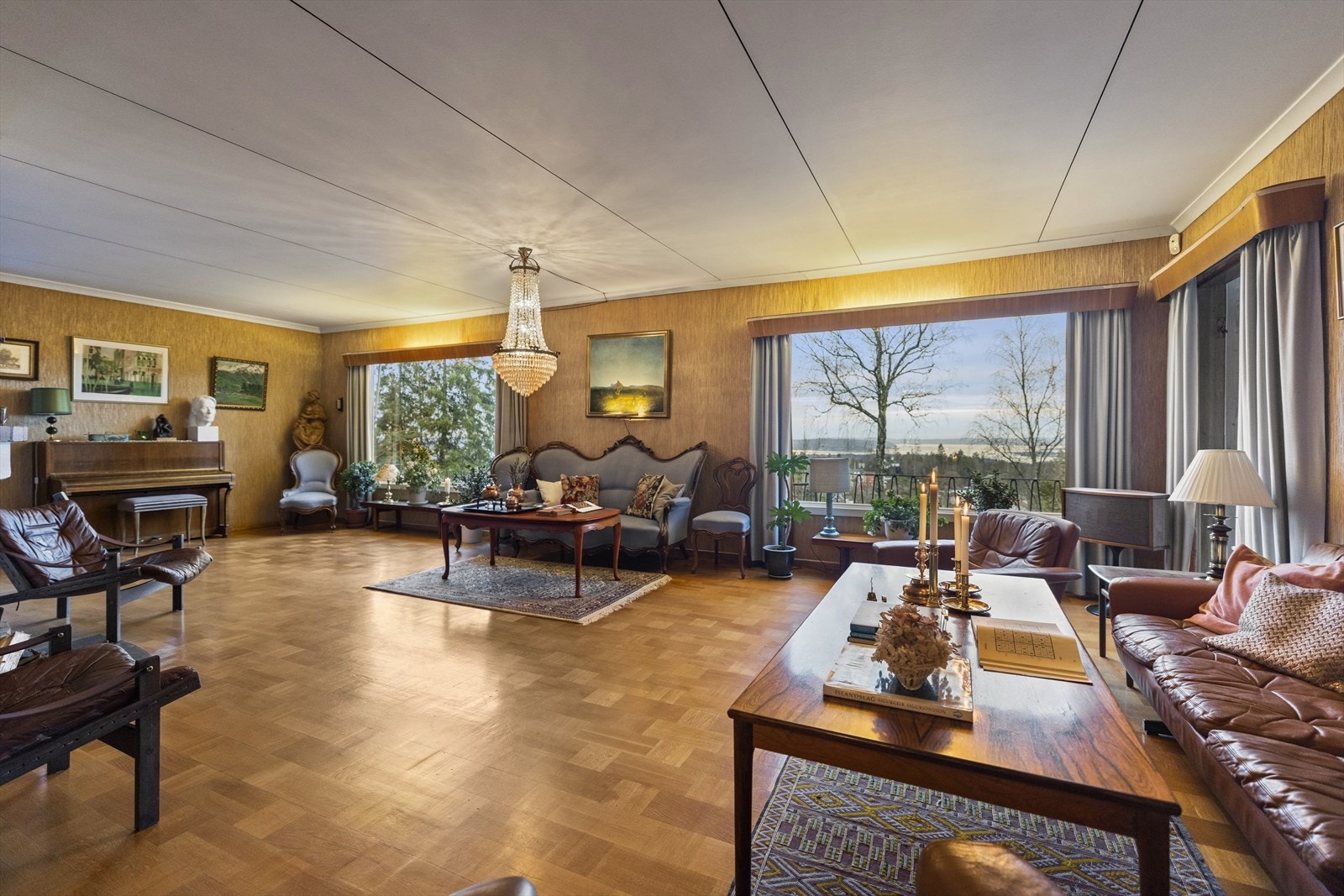 Stuen sett fra spisestuen. Det er ruteparkett på gulvet og takess plater i himlingen. Galleribilde