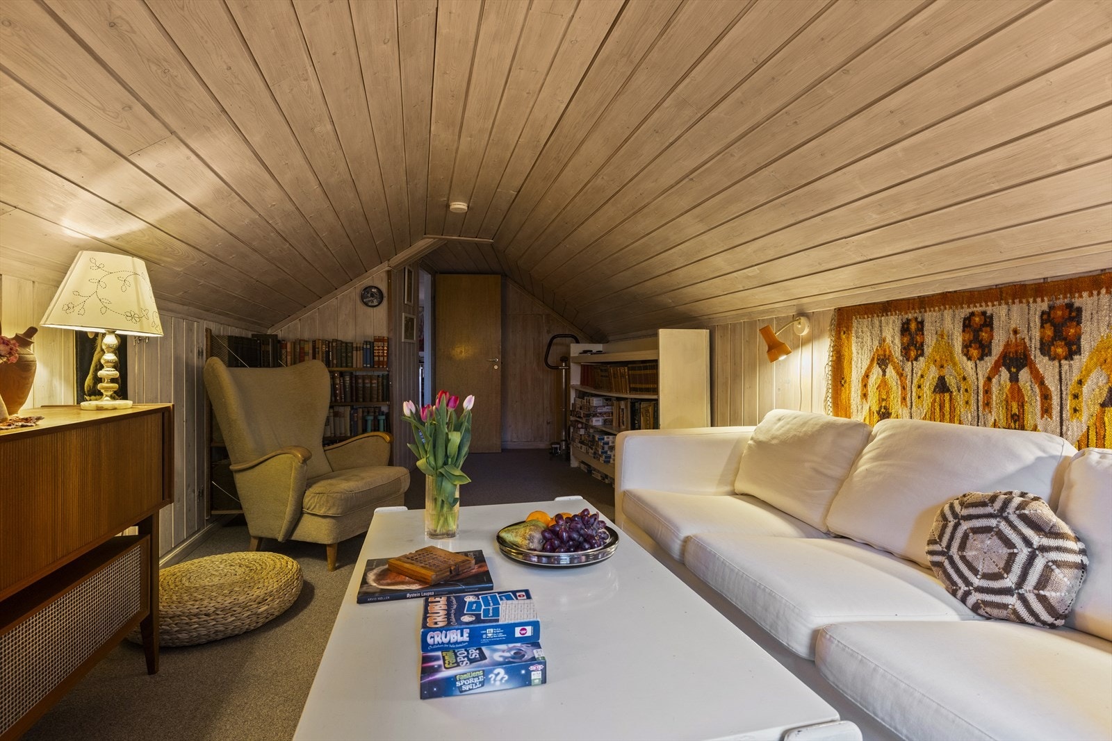 Tørkeloftet er i dag innredet som en loftsstue. Det er adkomst til lagring gjennom dør i kortveggen. Det er også ekstra lagring i knevegg til venstre i bildet. Galleribilde