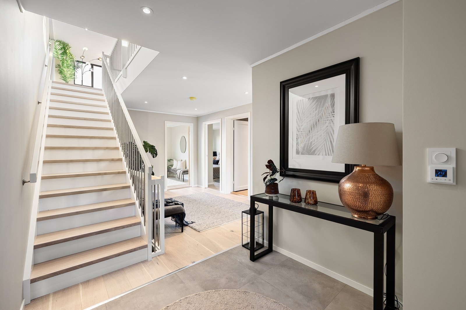 Lys og åpen entré med trappeforbindelse til boligens øvrige etasjer. Galleribilde