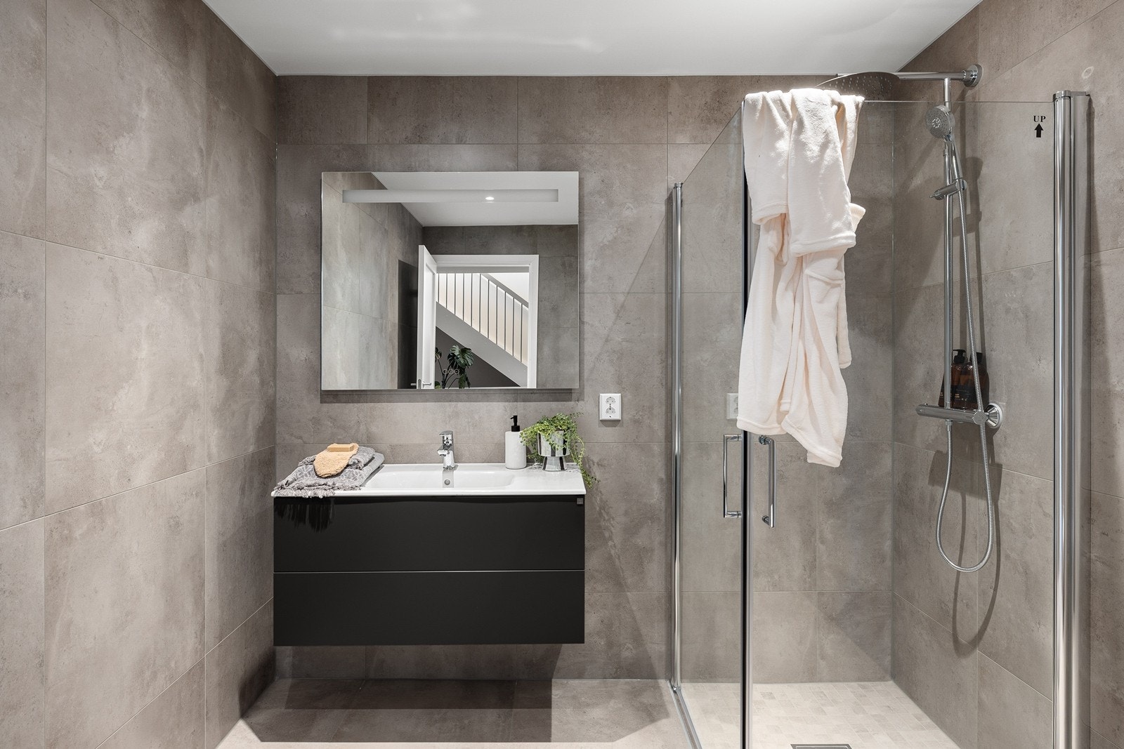 Badet er utstyrt med moderne innredning, vegghengt toalett og dusjhjørne. Galleribilde