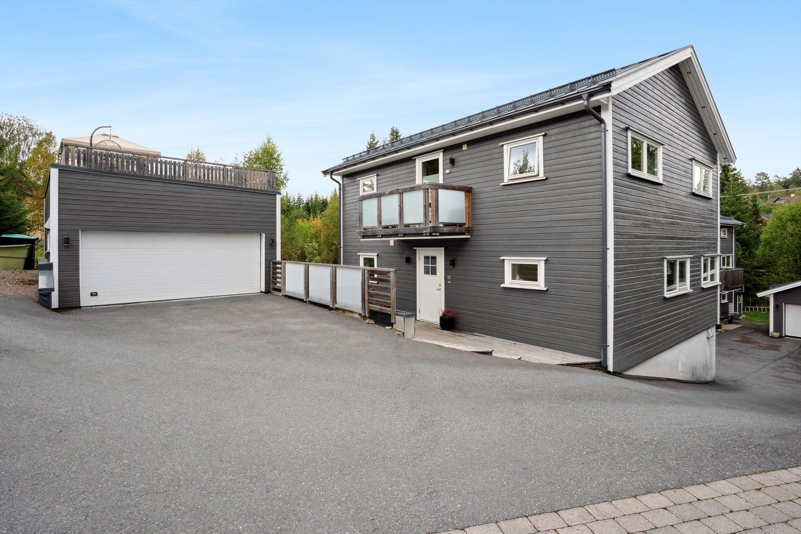 Asfaltert gårdsplass. Boligen var nybygget i 2017 og garasjen var nybygget i 2018. Galleribilde