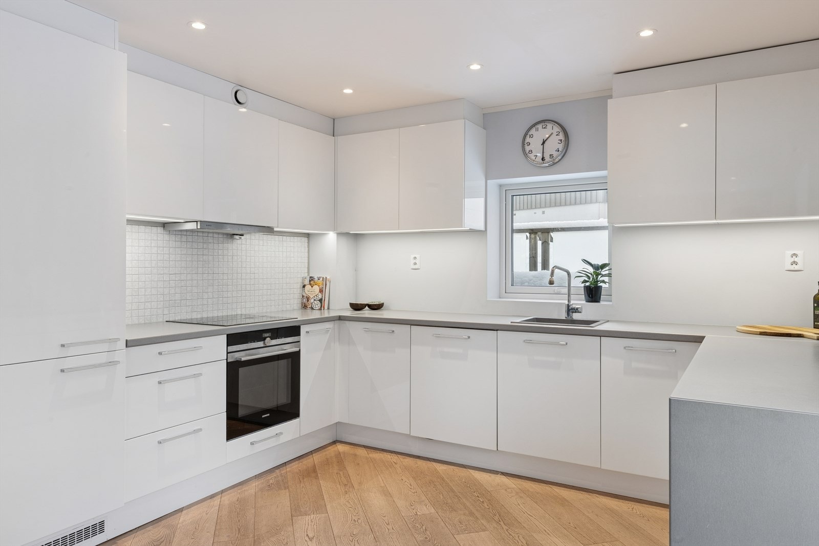 Hvite, slette fronter og mekanisk avtrekk fra ventilator sikrer et effektivt kjøkkenmiljø. Galleribilde