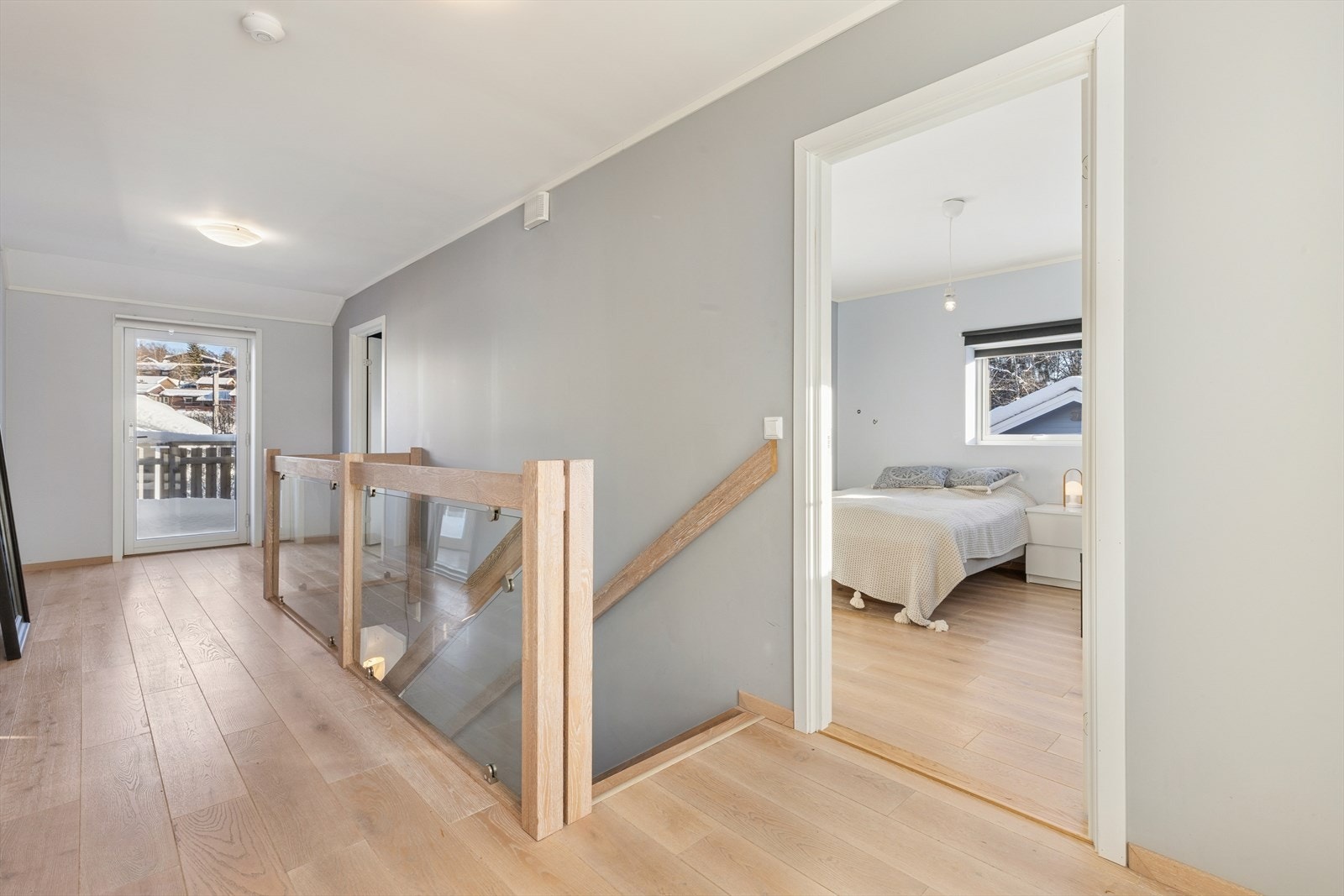 Eikeparkett og malte flater gir et stilrent uttrykk i gangen, med utgang til balkong. Galleribilde