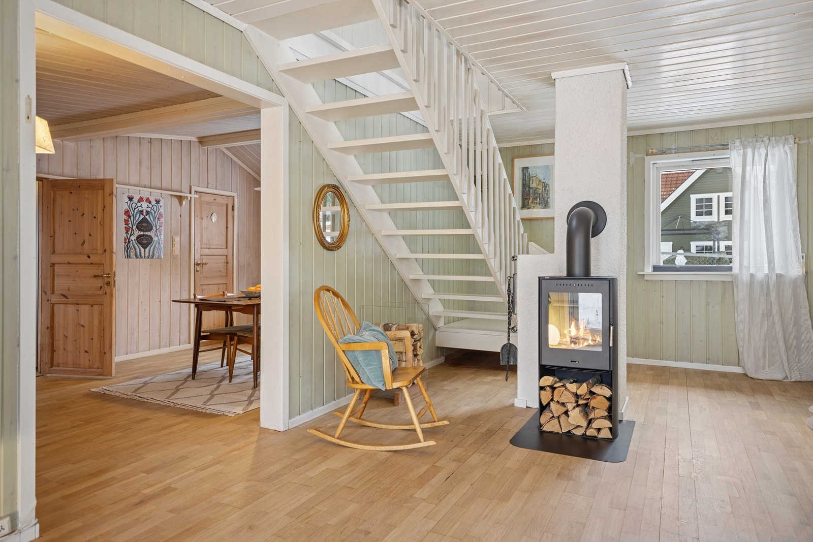 Det hvitmalte tretaket løfter romfølelsen ytterligere. Fra stua er det trapp opp til loftetasjen. Galleribilde
