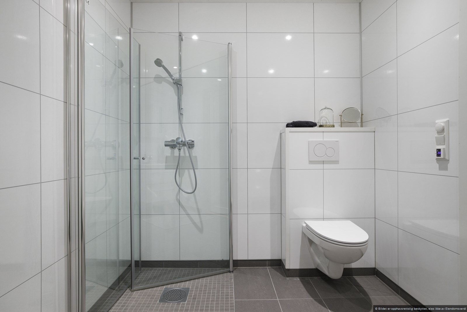 Downlights i himling, dusj med glassdører, vegghengt toalett og opplegg for vaskemaskin. Galleribilde